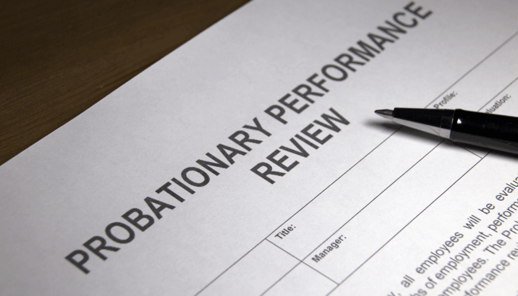 Document labeled “Probationary Performance Review” with a pen on top, representing what happens when you violate probation in Maryland.